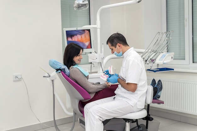 Paciente mujer hablando con el dentista acerca de la higiene bucal