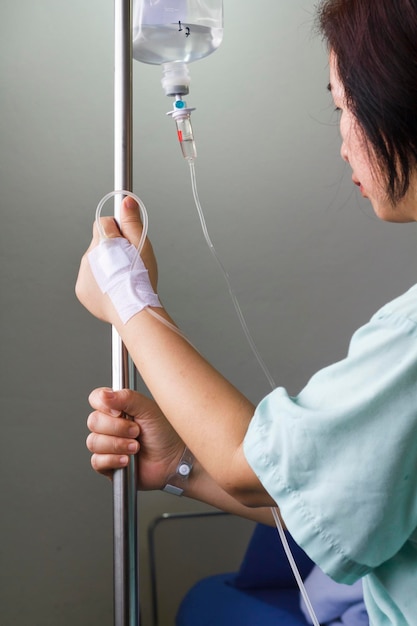 Paciente mujer en el hospital con solución salina intravenosa (iv)