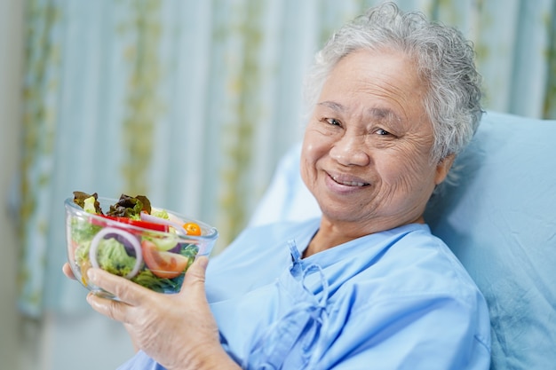 Paciente mujer mayor asiática desayunando en el hospital.