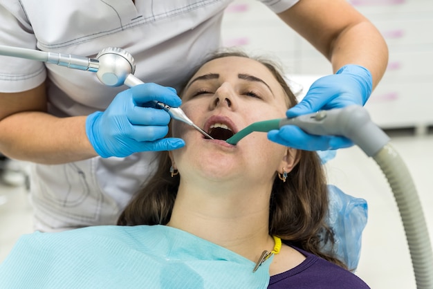 Paciente mujer en odontología haciendo procedimiento de blanqueamiento