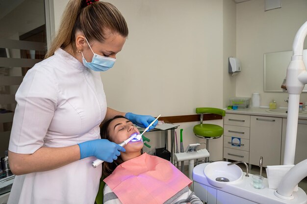 Paciente mujer recibe procedimiento para blanquear los dientes con lámpara uv