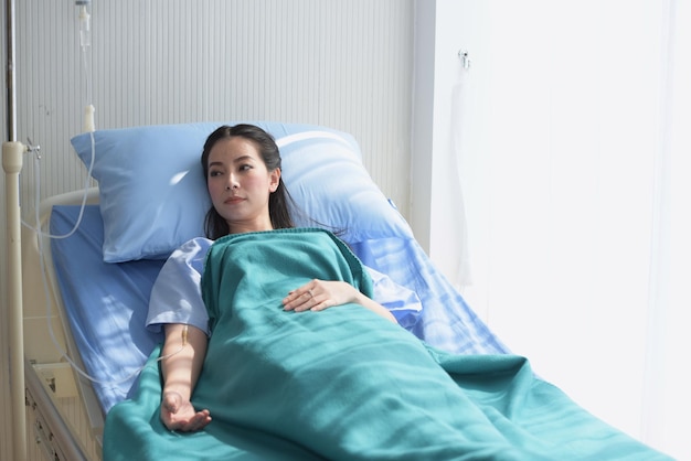 Paciente mujer relajándose en la cama del hospital