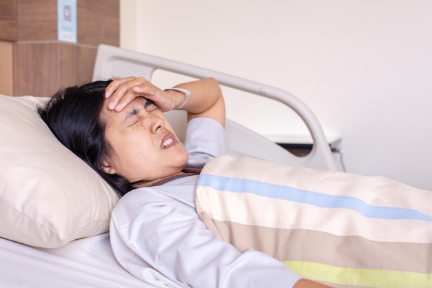 Paciente mulher asiática com forte dor de cabeça ou enxaqueca no hospital