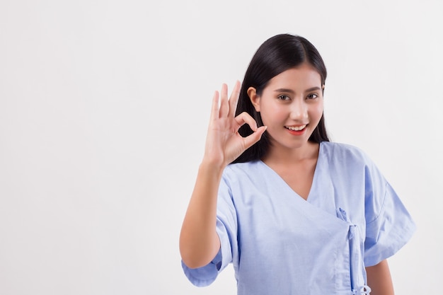 Paciente mulher ferida apontando para cima gesto com a mão ok