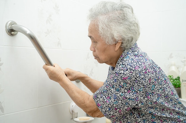 Paciente mulher idosa ou idosa asiática usando banheiro banheiro lidar com segurança em enfermaria de hospital