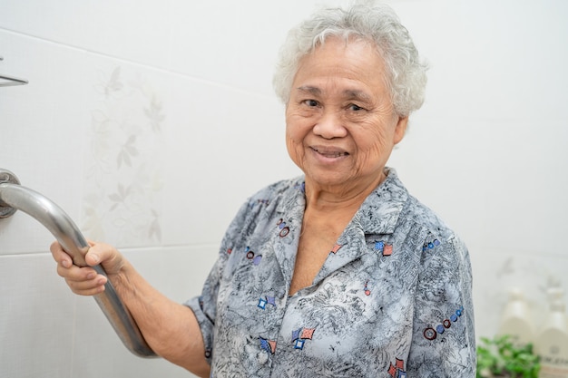 Paciente mulher sênior asiática usar banheiro banheiro lidar com segurança.