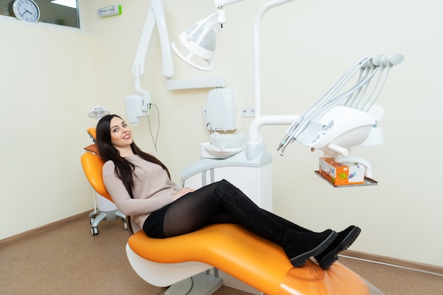 Paciente niña esperando un médico en una silla en el dentista.