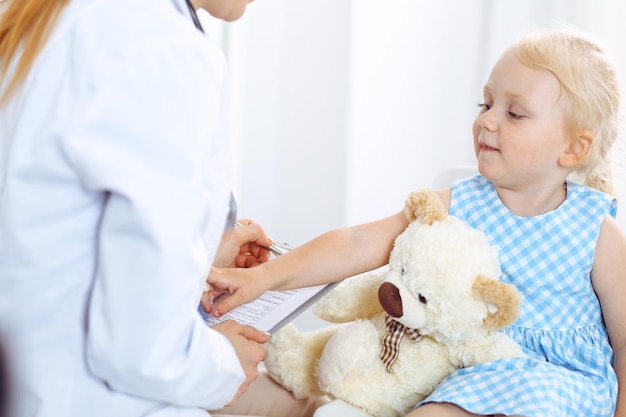 Paciente niño sonriente feliz en la inspección médica habitual. Médico y paciente en la clínica. Medicina, conceptos sanitarios.