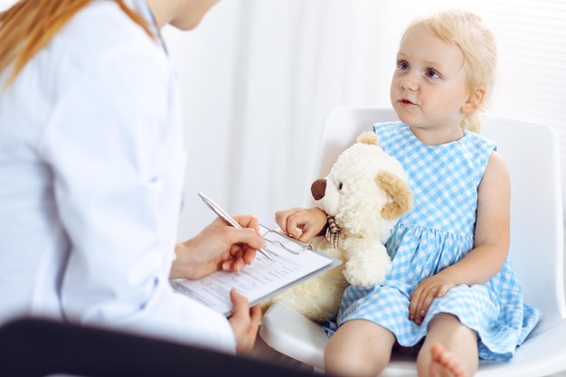 Paciente niño sonriente feliz en la inspección médica habitual. Médico y paciente en la clínica. Medicina, conceptos sanitarios.