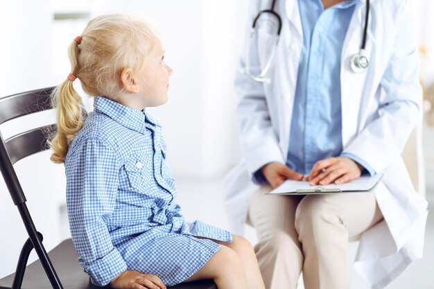 Paciente niño sonriente feliz en la inspección médica habitual. Médico y paciente en la clínica. Medicina, conceptos sanitarios.