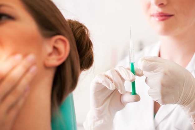 Foto paciente no dentista recebendo anestesia