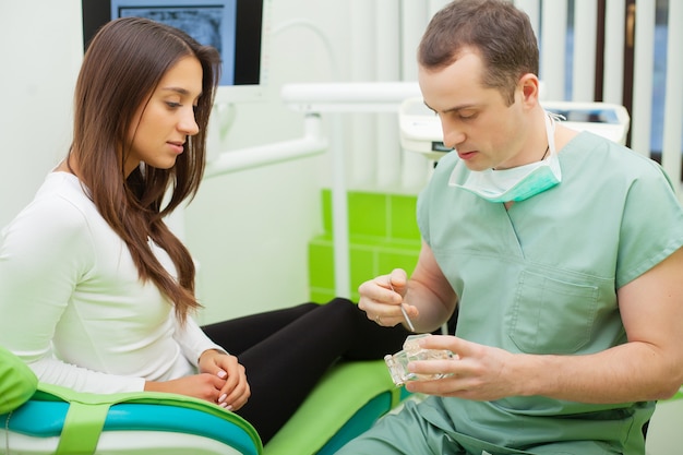 Paciente en odontología. Linda mujer visitando a su dentista en clínica