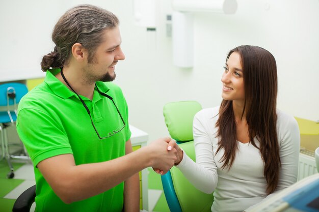 Foto paciente en odontología. linda mujer visitando a su dentista en clínica