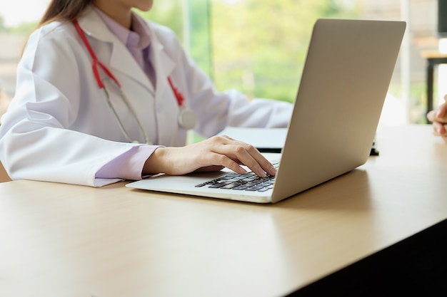 Paciente ouvindo atentamente um médico explicando os sintomas do paciente ou fazendo uma pergunta enquanto discutem a papelada juntos em uma consulta