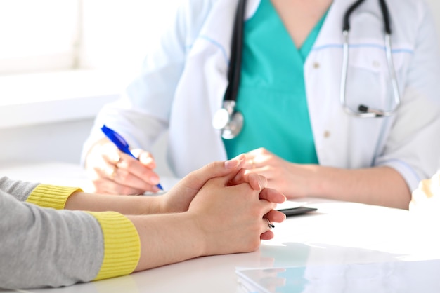 Paciente ouvindo seu médico sentado à mesa Mãos fechadas