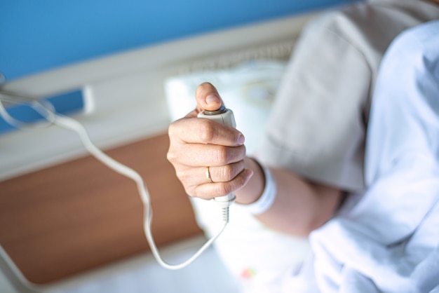 Paciente pressionando o botão de chamada de enfermeira segurando ajuda em cuidados de saúde de emergência
