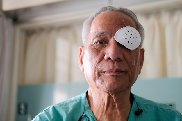 Paciente que cubre el ojo con un escudo protector después de una cirugía de cataratas en el hospital