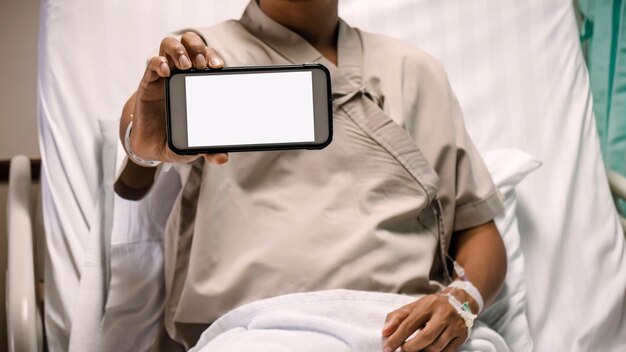 Paciente que muestra el monitor del teléfono inteligente en el hospital