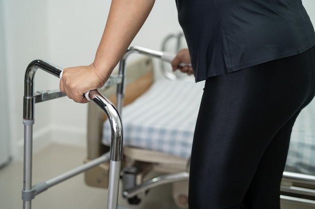 Paciente senhora asiática dor nas costas, cintura, perna e lombar ortopédica com andador.