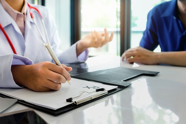 Paciente sentado com o médico para consulta no escritório do hospital