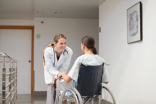 Paciente sentado en una silla de ruedas frente a un médico