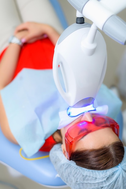 Foto el paciente se somete a un procedimiento de blanqueamiento dental con una lámpara ultravioleta.