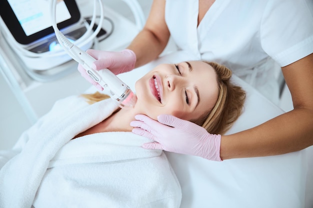 Paciente de spa feliz disfrutando del procedimiento cosmético