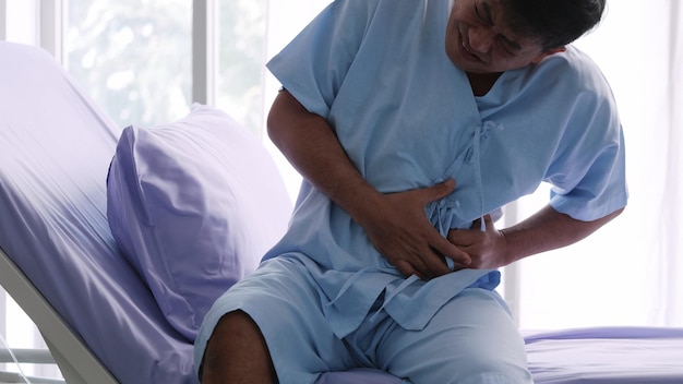 Foto paciente varón asiático anciano es hospitalizado con dolor de estómago