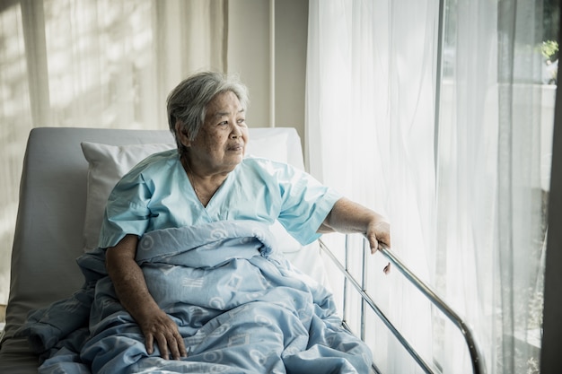 Pacientes idosos sentados na cama esperando que os parentes visitassem com a solidão.