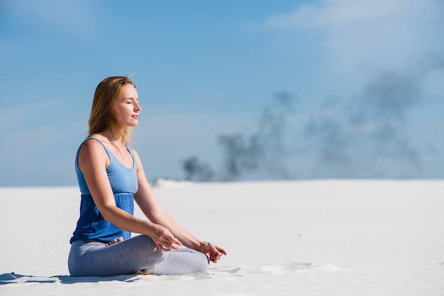 Pacífica mulher senta-se em pose de ioga de lótus