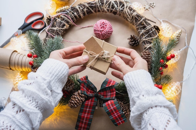 Packen Sie ein Geschenk für Weihnachten und Neujahr in Kraftpapierkegel, Bandschere, Tags mit Mock-up-Naturdekor, handgefertigt, DIY, festliche Stimmung, Flatlay-Hintergrund