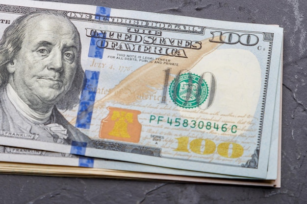 Pacote close-up de notas de cem dólares em um fundo preto. Foto horizontal