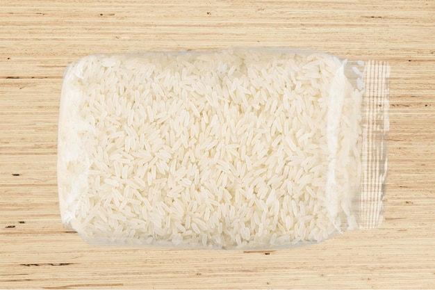 Pacote de arroz cru em fundo de madeira