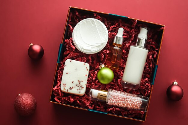 Pacote de assinatura de caixa de beleza de férias de natal e produtos de cuidados de pele de luxo flatlay cosmetic flat lay em cosméticos de fundo coral como presente de feriado ou entrega de compras