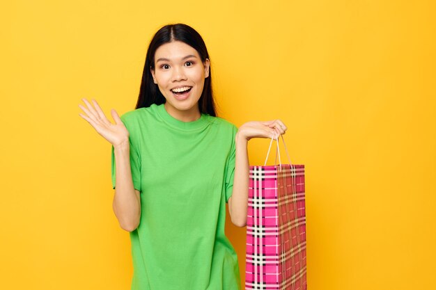 Pacote de camisetas verdes muito morena comprando fundo amarelo inalterado