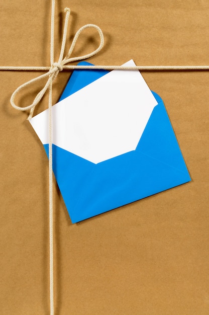 Foto pacote de papel pardo com envelope azul