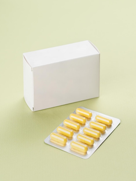 Pacote de produto branco em branco, caixa de remédio, droga, maquetexanao lado da caixa, há um blister com uma visão superior de vitamina local para logotipo e texto