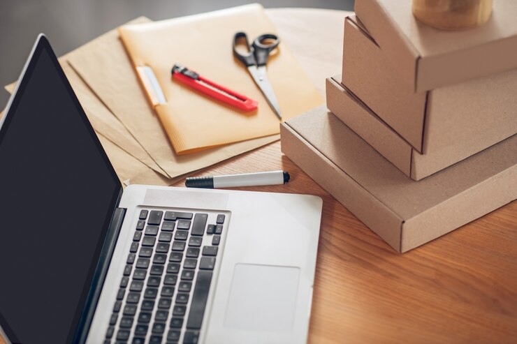 Foto pacotes de laptop e produtos empilhados na mesa