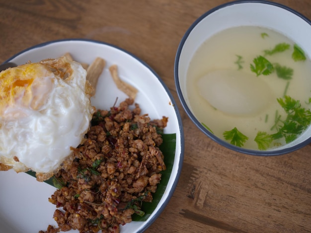 Pad Krapow MOO Cerdo con albahaca tailandesa con arroz y fondo de huevo frito Plato de cocina tailandesa con cerdo picado, albahaca, soja y salsas de ostras Comida tailandesa Copiar espacio