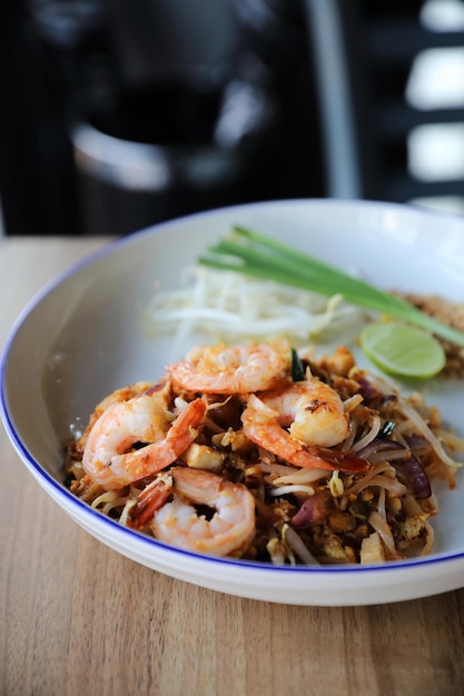 Pad thai con camarones. Comida tailandesa sobre fondo de madera