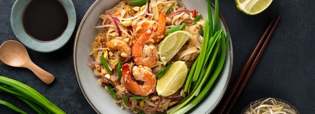 Pad Thai con camarones sobre un fondo de piedra oscura, vista superior