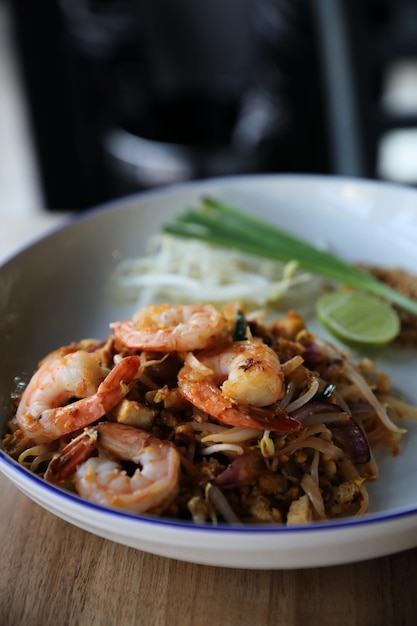 Pad thai com camarão. Comida tailandesa em fundo de madeira