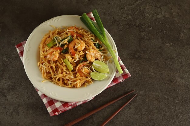 Pad thai é um prato de macarrão de arroz frito comumente servido como comida de rua na Tailândia.