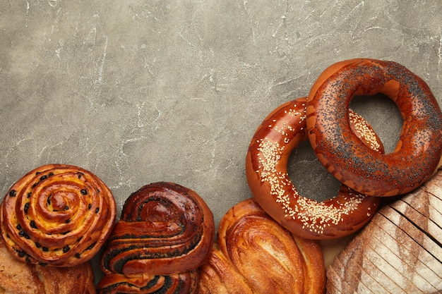 Foto padaria vários tipos de pão rolos de pão bagel bolo doce em fundo cinza espaço para texto