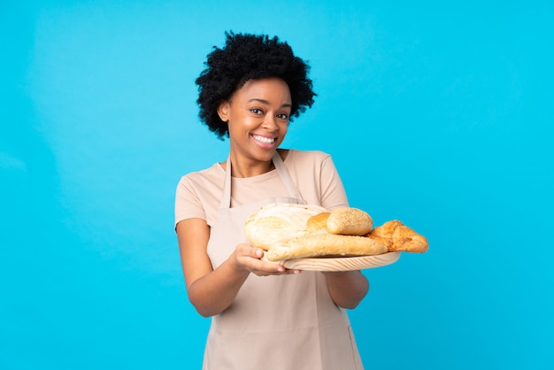 Padeiro americano africano, segurando uma mesa com vários pães