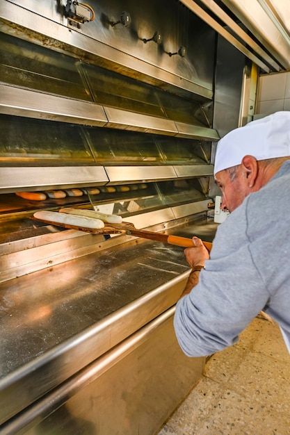 Foto padeiro assando pão fresco na padaria