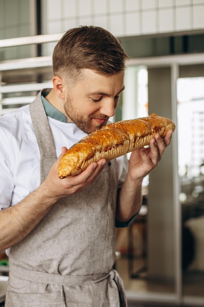 Padeiro de homem com pão fresco na casa de padeiro