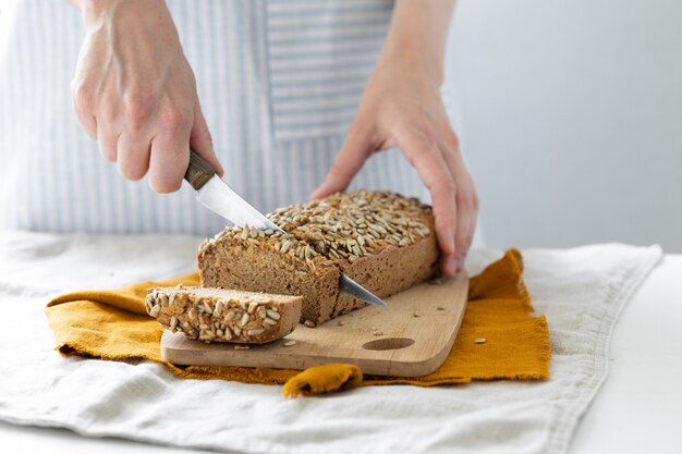 Padeiro europeu segurando pão de trigo sarraceno mulher branca com um avental leve segurando massa fermentada caseira