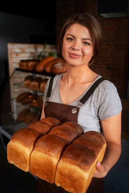 Padeiro feminino com pão assado na confeitaria