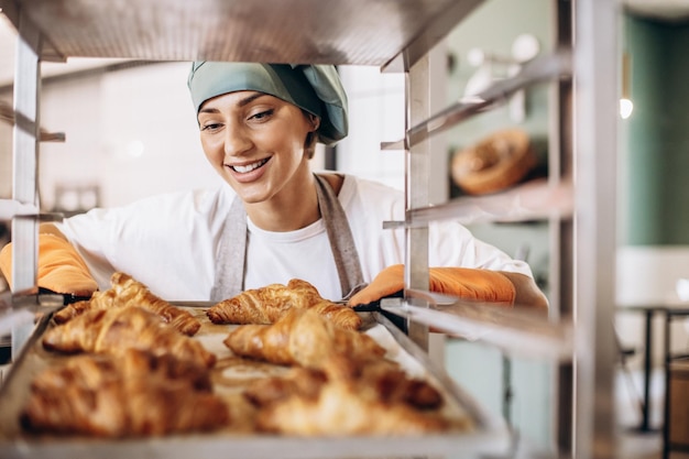 Padeiro feminino na cozinha segurando croissant